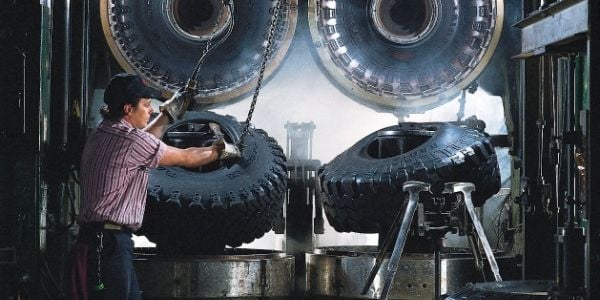 A man hooks the rubber tire with a hook chain.