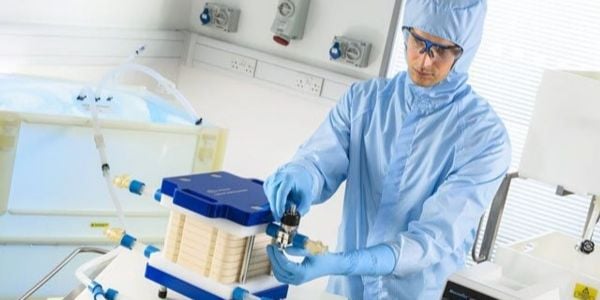 A man in a protective suit is doing an experiment.