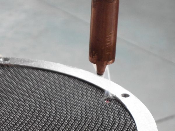 The spot welding robot is welding the round filter disc.